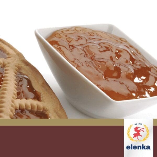 A close-up of a lattice-topped crostata slice with a glossy apricot filling next to a white square bowl filled with caramel-colored sauce. Below is a brown banner featuring the Elenka logo, adorned with a golden lion and the text "Elenka dal 1959." The delicious filling is made using Elenka Apricot Jam Preserve for Crostata, Croissants, Pastries, and Baked Goods (1x12Kg).