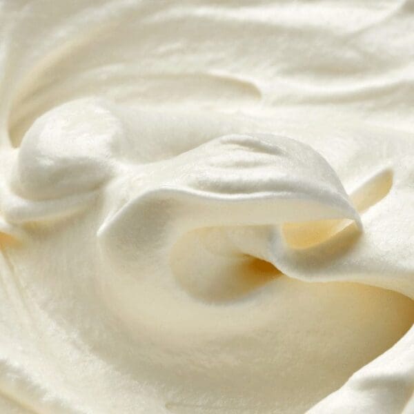 A close-up of smooth, creamy whipped cream crafted from Elenka Base Montelenka Vegetable Cream (20x1Kg case) showcases swirls and soft peaks, forming a textured surface in a soft off-white hue, hinting at its light and airy consistency.