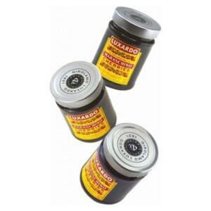 Three jars of Luxardo Maraschino Cherries with yellow and red labels are arranged diagonally against a white background.