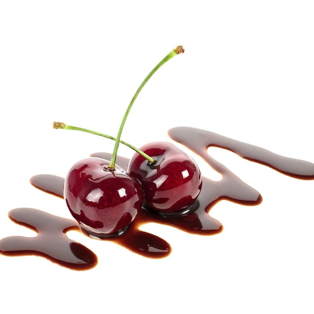 Two ripe cherries in liquid chocolate isolated on a white background. Fondue cherries.